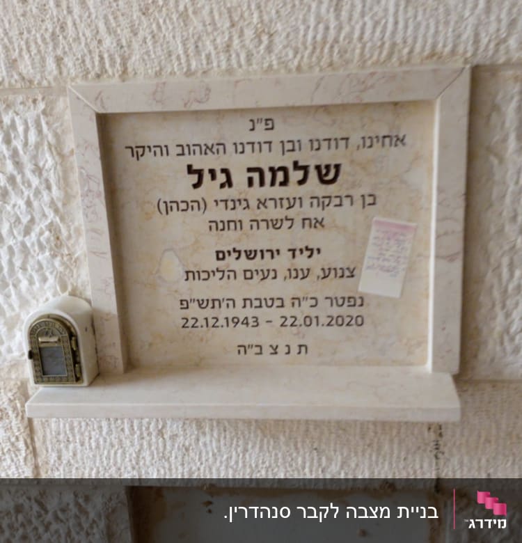 מצבה עם כיתוב בעברית ותמונה קטנה